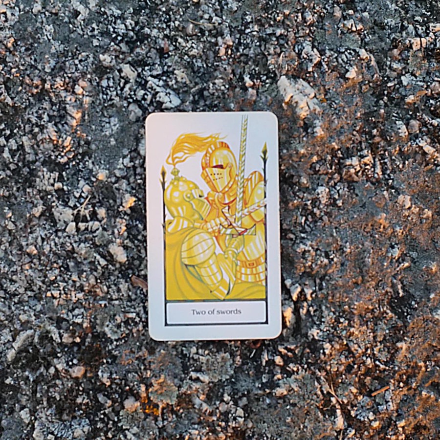 The Two of Swords tarot card photographed outdoors
