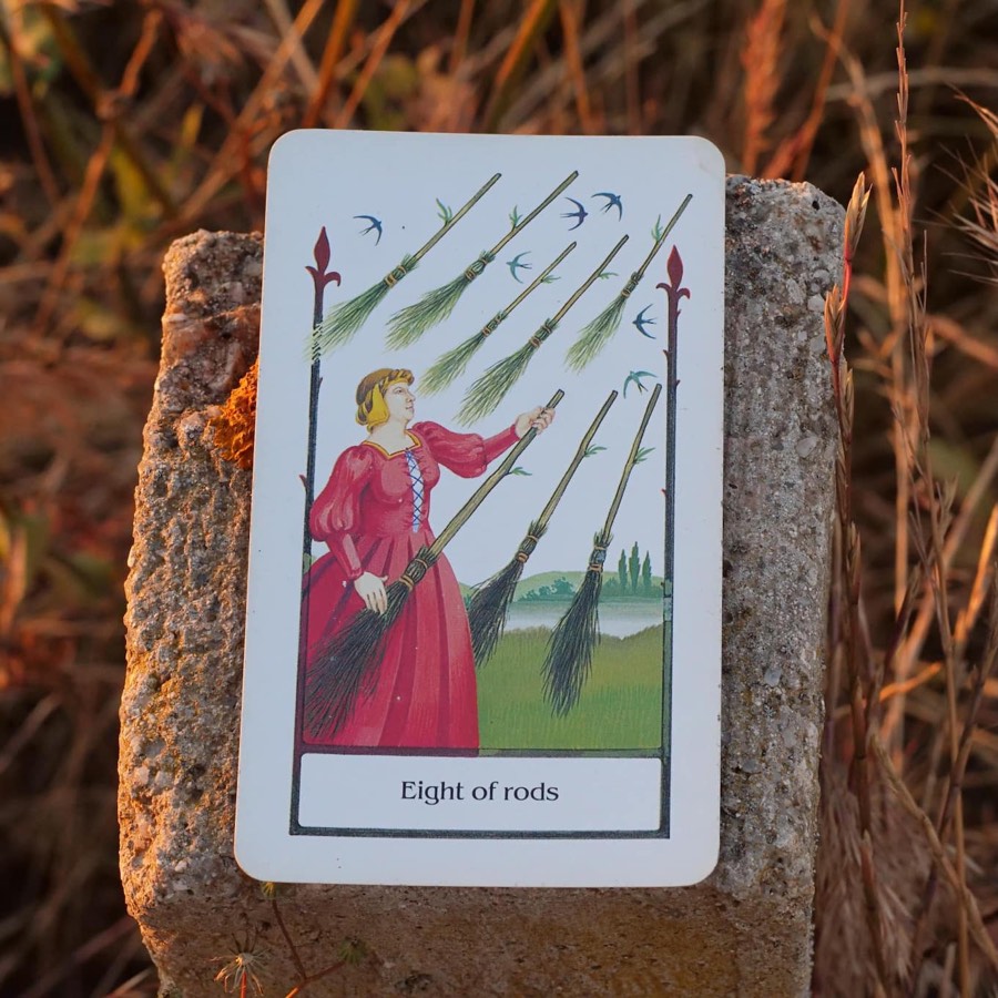 The Eight of Wands tarot card photographed outdoors