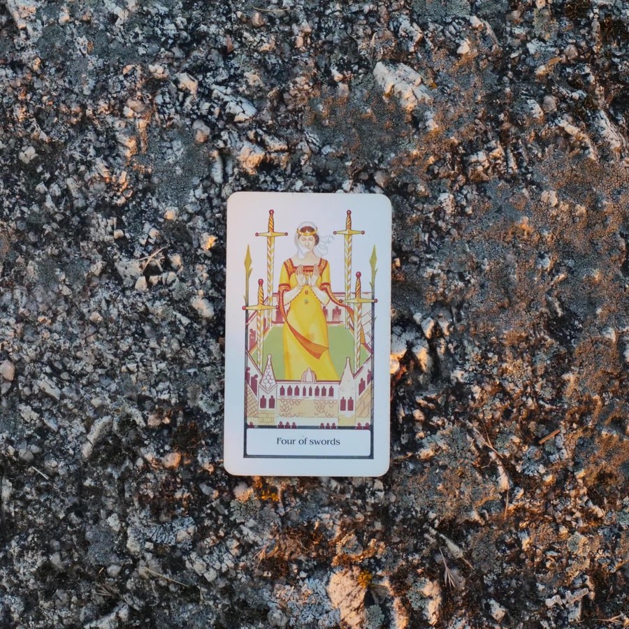 The Four of Swords tarot card photographed outdoors