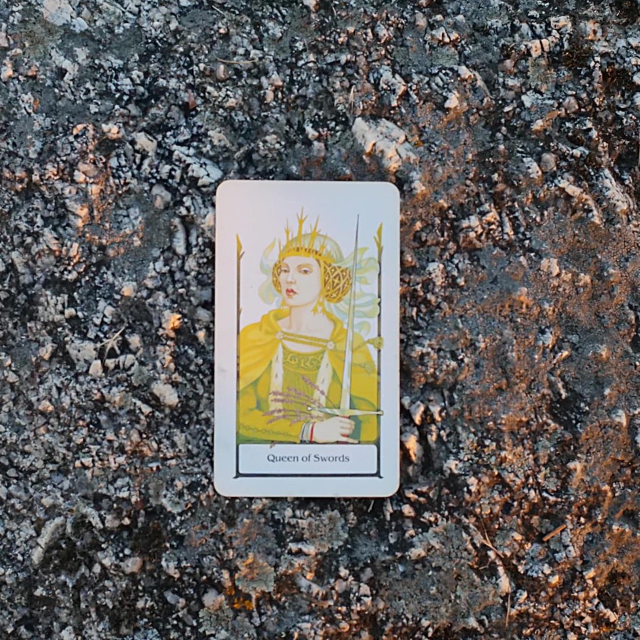 The Queen of Swords tarot card photographed outdoors